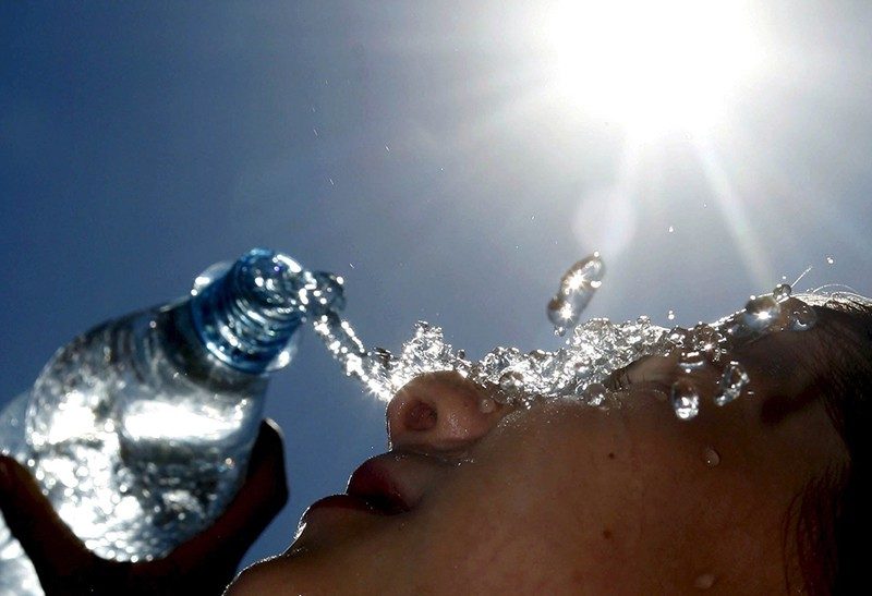 Picture shows person emptying water over her head.